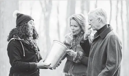  ?? JUSTIN TANG THE CANADIAN PRESS ?? King Philippe and Queen Mathilde of Belgium taste maple sap at the Richelieu Park Sugar Shack in Ottawa Monday.