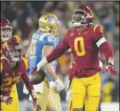  ?? Associated Press ?? USC defensive end Korey Foreman (0) celebrates with defensive back Bryson Shaw (27) and defensive lineman Brandon Pili after intercepti­ng a pass to clinch a 48-45 victory over UCLA, Saturday, in Pasadena.