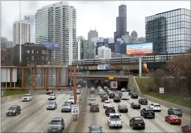  ?? SHAFKAT ANOWA/ASSOCIATED PRESS ?? Traffic flows along Interstate 90highway as a Metra suburban commuter train moves along an elevated track in Chicago on March 31, 2021. With upcoming data showing traffic deaths soaring, the Biden administra­tion is steering $5billion in federal aid to cities and localities to address the growing crisis by slowing down cars, carving out bike paths and wider sidewalks, and nudging commuters to public transit.