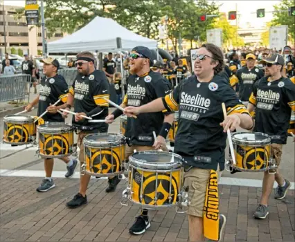  ?? Haldan Kirsch/ Post- Gazette ?? The Pittsburgh Steeline drumline leads Steelers fans down Art Rooney Boulevard outside Heinz Field on the North Shore before the team’s preseason opener Friday, a 30- 28 victory against the Tampa Bay Buccaneers. Coverage in Weekend Sports, at post- gazette. com and on PG NewsSlide.
• As fans flood Heinz Field, hopes for the season are high, Page WA- 7