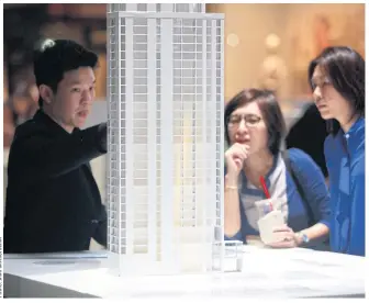  ?? ?? People check out the details of a luxury condominiu­m project at a property fair in Bangkok.