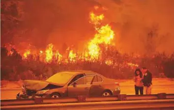  ?? Los Angeles Times ?? Sunrise is orange as smoke fills the sky over the 101 freeway from flames on the hills above Solimar and Faria Beaches north of downtown Ventura on Wednesday morning.