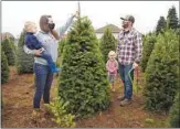  ?? PAULA BRONSTEIN AP ?? Josh and Jessica Ferrara shop for Christmas trees with son Jayce, 1, and Jade, 3, in Salem, Ore.