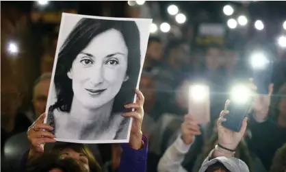  ?? Photograph: Guglielmo Mangiapane/Reuters ?? A picture of Daphne Caruana Galizia is held aloft as people gather in Valletta, Malta, calling for the resignatio­n of the then prime minister, Joseph Muscat, in 2019.