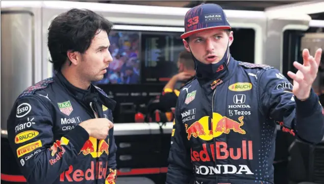  ??  ?? Sergio Pérez y Max Verstappen hablan en el garaje de Red Bull durante el gran premio de Hungría, la última carrera que se disputó antes de las vacaciones en Hungarorin­g.