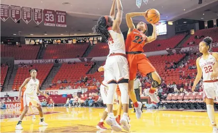  ?? GARY STEPIC/FOR THE JOURNAL ?? New Mexico’s Mykiel Burleson (22) attempts to put up a shot against Oklahoma’s Shaina Pellington (14) during their matinee Saturday.