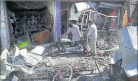  ?? AP ?? Men look at the remains of their properties at the site of a suicide attack in Kabul on Monday.