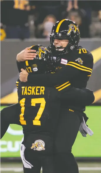  ??  ?? Lirim Hajrullahu embraces Luke Tasker after kicking a game-winning field goal during the Ticats’ record-setting 150th season. Hamilton fans are in a frenzy over the team’s success. PHOTOS: PETER POWER/CANADIAN PRESS