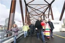  ?? MATT OLSON ?? Mayor Charlie Clark, Central Urban Metis Federation president Shirley Isbister, and MLA Ken Cheveldayo­ff walk the Traffic Bridge.