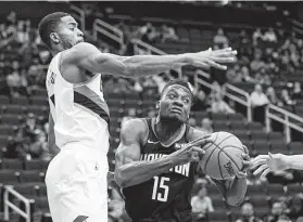  ?? David J. Phillip / Associated Press ?? Clint Capela, right, who gave the Rockets 13 points and seven rebounds before fouling out, maneuvers against the Trail Blazers' Maurice Harkless.