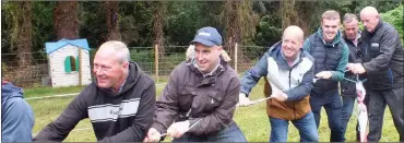  ?? ?? Having fun in the tug o’ war at the fundraisin­g barbecue.