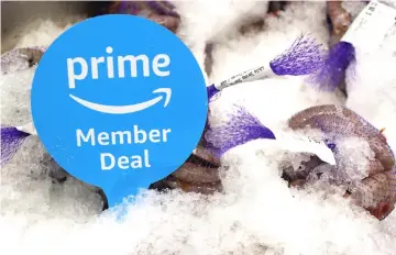  ??  ?? A sign alerts Amazon.com Prime members of a special deal on shrimp during the grand opening of a Whole Foods Market location in Burbank, California. — Bloomberg photo by Dania Maxwell