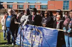  ?? Jesse Leavenwort­h/Hearst Media Group ?? Connecticu­t NAACP President Scot X. Esdaile, center in black hat, and other organizati­on leaders and members stand in front of RHAM High School.