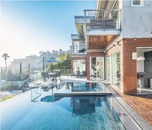  ?? CALVIN BAINES ?? The infinity pool takes advantage of the west-facing, hillside location of the three-level house which features pocket doors for easy indoor-outdoor access.