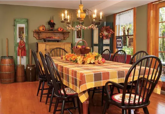  ??  ?? Below: Sunlight streams through the dining room windows and highlights the wide-plank pumpkin-pine floors. Shutters situated on either side of an antique cupboard and mantel shelf create a striking focal point at one end of the room and combine to balance the scale of the expansive dining table. 47