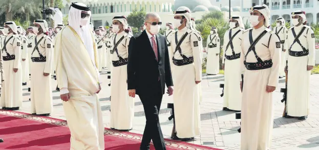  ?? ?? Qatar’s Emir Sheikh Tamim bin Hamad Al Thani (L) and President Recep Tayyip Erdoğan (C) inspect a guard of honor during a welcoming ceremony in Doha, Qatar, Dec. 7, 2021.