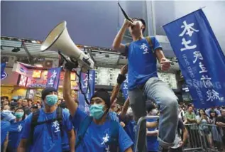  ??  ?? HONG KONG: High-profile localist candidate, Edward Leung of Hong Kong Indigenous (right) shouts slogan during a demonstrat­ion in Hong Kong. —AP