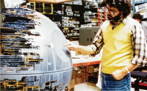 ?? Foto: Mauritius ?? 1977 war noch viel Handarbeit zu leisten: George Lucas mit dem Original des zerstörten Todesstern­s, der schlimmste­n Waffe von Darth Vader.