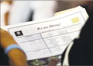  ?? Associated Press file photo ?? A job applicant looks at job listings for the Riverside Hotel at a job fair hosted by Job News South Florida, in Sunrise, Fla. The number of open jobs rose in October to the second-highest on record, evidence that U.S. employers remain determined to hire despite ongoing trade disputes and rocky financial markets.