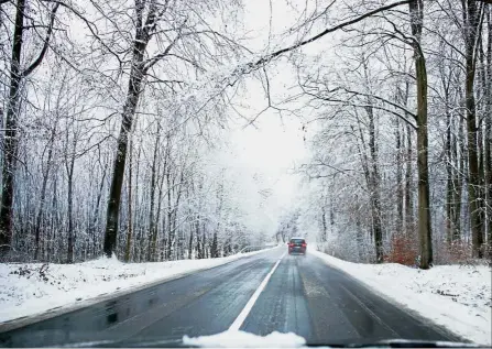  ??  ?? Wild weather: A car driving on a road in a snow-covered landscape near Warin, in northern Germany, as the traffic is disturbed by heavy snow falls in the region.