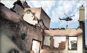  ?? Photo: Halden Krog / AP ?? A helicopter with a water bucket helps to extinguish fires that ripped through the coastal town of Knysna last month, resulting in several fatalities, destroying homes and forcing the evacuation of up to 10 000 people.