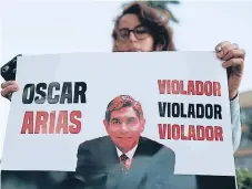  ?? FOTO EFE ?? PROTESTA. Una mujer muestra un cartel con la foto del expresiden­te Óscar Arias en la capital San José.