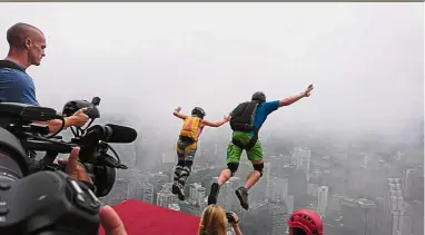  ??  ?? Two BASE jumpers leaping off in tandem during the first day of the KL Tower Internatio­nal Jump Malaysia event, now into its 17th edition. Going over the edge: