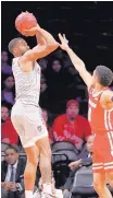  ?? KATHY WILLENS/ASSOCIATED PRESS ?? UNM guard JaQuan Lyle, left, shoots as Wisconsin’s D’Mitrik Trice defends.