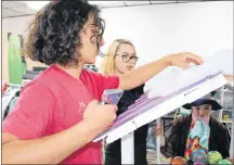  ?? MILLICENT MCKAY/JOURNAL PIONEER ?? Sam Edgcomb, left, and Ashley Perry work on the roof of Willy Wonka’s candy cart. The pair, along with other students and staffers at Spotlight School of Arts, are eagerly preparing for the Lobster Carnival parade and their upcoming performanc­e of”...