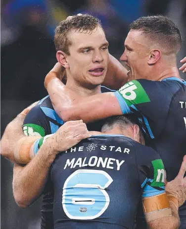  ??  ?? Thom Trbojevic (left) celebrates with teammates after scoring one of his three tries during the Blues’