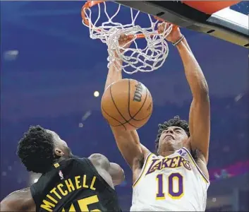  ?? Sue Ogrocki Associated Press ?? MAX CHRISTIE (10), shown dunking over Cavaliers guard Donovan Mitchell during the Lakers’ 121-115 win on Saturday in Cleveland, has met the challenge of defending against some of the league’s toughest matchups.