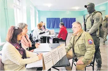  ?? — AFP photo ?? Konstantin Ivashchenk­o (third right), former CEO of the Azovmash plant and appointed pro-Russian mayor of Mariupol, visits a polling station as people vote in a referendum in Mariupol.