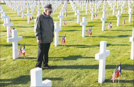  ?? Kiran Ridley / Getty Images ?? U.S. veteran Kirt Robbins pays his respects at dawn on the 75th anniversar­y of the D-Day landings at the American Cemetery on Thursday in Colleville-sur-Mer, France. .