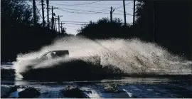  ?? RONALD W. ERDRICH — THE ABILENE REPORTER-NEWS VIA AP ?? A pickup sends a wake of snow melt high into the air as the driver plows through a large puddle at an intersecti­on in Abilene, Texas, on Friday.