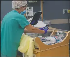  ??  ?? Nurse Amanda Vaughan takes photos and helps new mom Clarissa Munoz, who is infected with covid-19, see her baby via iPad at DHR Health. Munoz was separated from her child after giving birth.