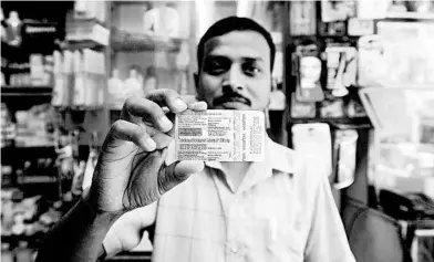  ?? RAFIQ MAQBOOL/AP ?? A chemist displays hydroxychl­oroquine tablets in Mumbai, India. The country is producing 3 million tablets of the drug per month.