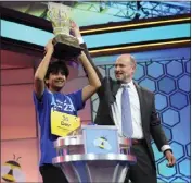  ?? NICK WASS — THE ASSOCIATED PRESS ?? Dev Shah, 14, from Largo, Florida, lifts the trophy next to Scripps CEO Adam Symson after he won the Scripps National Spelling Bee finals Thursday in Oxon Hill, Maryland.