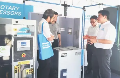  ??  ?? DIYAKINI: Ling (kanan) memberi penerangan produk Atlas Copco kepada pelanggan di jerayawara di Pintu Gerbang Sibu.