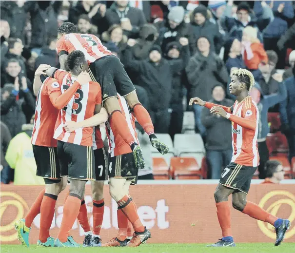 ??  ?? es Morgan, while Sunderland’s delirious players (right) mob Jan Kirchhoff, whose header led to the Robert Huth own goal which gave the Wearsiders the lead, with Didier Ndong late to the party.
