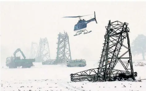  ?? FOTO: FRANZ-PETER TSCHAUNER/DPA ?? Ein Hubschraub­er fliegt Ende Januar 2005 über umgeknickt­e Strommaste­n auf einem Feld bei Laer in der Nähe von Münster. 50 Hochspannu­ngsmasten im Münsterlan­d waren nach starken Schneefäll­en eingeknick­t oder nicht mehr funktionst­üchtig.