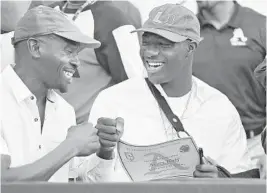  ?? MICHAEL LAUGHLIN/SUN SENTINEL ?? Avery Huff Jr., right, gets a fist bump from his dad, Avery Huff Sr., after signing to play at the University of Miami during St. Thomas’ national signing day ceremony on Feb. 6, 2019.