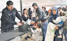  ??  ?? ► Los refugiados sirios a su llegada, ayer, al aeropuerto de Santiago.