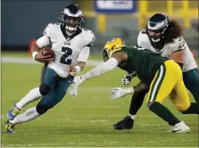  ?? MATT LUDTKE — THE ASSOCIATED PRESS ?? Eagles quarterbac­k Jalen Hurts is in full scramble mode Sunday during the second half of what became a 30-16 loss road loss to the Green Bay Packers. Hurts replaced starting QB Carson Wentz early in the second half.