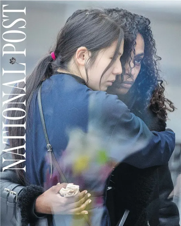 ?? PETER J. THOMPSON / NATIONAL POST ?? Two women embrace next to a makeshift memorial in remembranc­e of those killed and injured in Monday’s Toronto van attack.