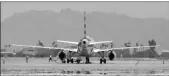  ?? Buy this photo at YumaSun.com PHOTO BY RANDY HOEFT/YUMA SUN ?? YUMA INTERNATIO­NAL AIRPORT PERSONNEL work around an American Airlines jet that made an emergency landing here early Monday afternoon.