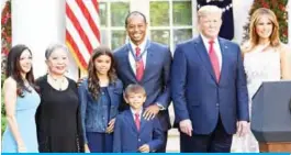  ??  ?? WASHINGTON: Profession­al golfer Tiger Woods (C) stands with his girlfriend Erica Herman (L), Kultida Woods (2L), Sam Alexis Woods (3L), Charlie Axel Woods (C-bottom), US President Donald Trump (2R), and US first lady Melania Trump (R) after a Presidenti­al Medal of Freedom ceremony in the Rose Garden of the White House , in Washington. —AFP