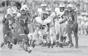  ?? MICHAEL LAUGHLIN/SUN SENTINEL ?? St. Thomas Aquinas running back Gemari Sands pulls away from the Cardinal Gibbons defense during their game Saturday. The Raiders host Dillard on Friday.