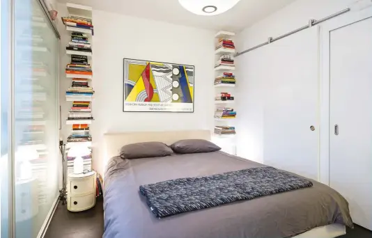  ??  ?? Floating bookshelve­s flank the B&B Italia bed from Kiosk; above it, a serigraph by Roy Lichtenste­in. George Nelson pendant and Kartell nightstand­s from Quasi Modo.