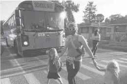  ?? RICK BOWMER/AP ?? Sandra Young and daughters Baylin, 5, and Paytin, 2, arrive at school in Salt Lake City, where the mayor imposed a mask mandate on schools despite Utah’s mandate ban.