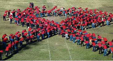  ?? — Reuters ?? Health workers and volunteers form a human ribbon to commemorat­e World AIDS day in San Salvador, El Salvador, December 1.